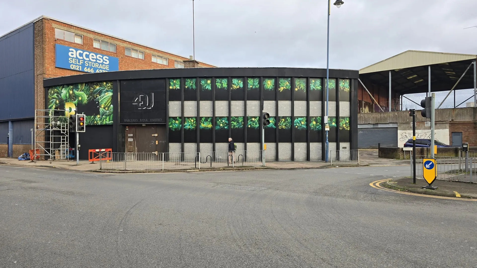Same corner building after installation of green foliage window graphics and a feature wall panel